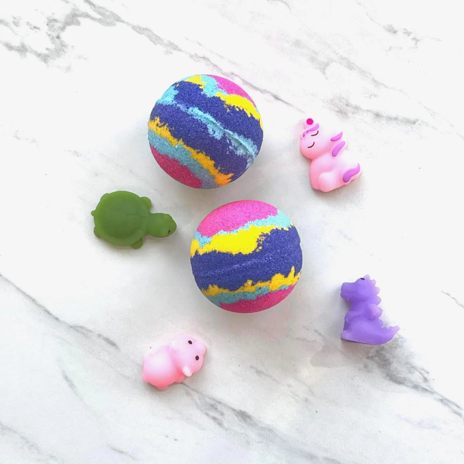 Two round bath bombs with colorful marbled patterns and four small animal-shaped bath salts in pink, green, and purple, arranged on a white marble surface.
Pop It Open & Pull Apart Mold Free Bath Toys	Jul 20, 2026

Sunday's Best Mochi Squishie Bath Bomb