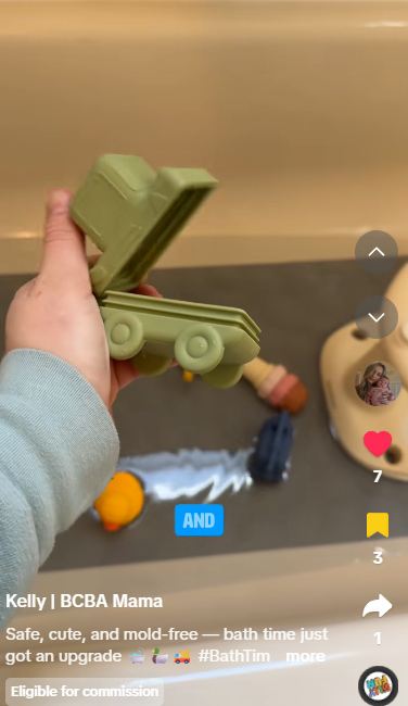 A hand holds an olive green plastic toy truck with a hinged lid, shown in a bathroom setting with a bathtub and other bath toys visible in the background. Bath Toys mold free pull apart